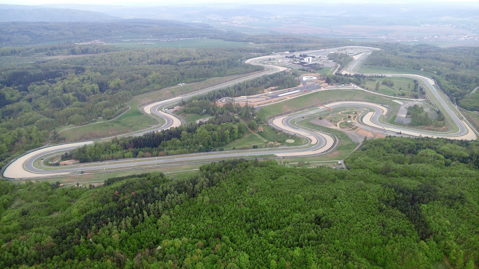 Automotodrom Brno z lotu ptaka: cała nitka toru wijąca się wśród zalesionych wzgórz